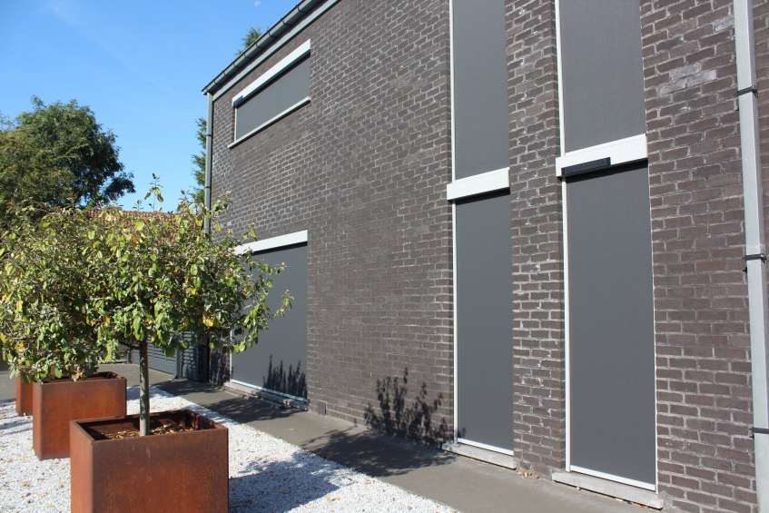 Donkere screens op de ramen van een modern gebouw